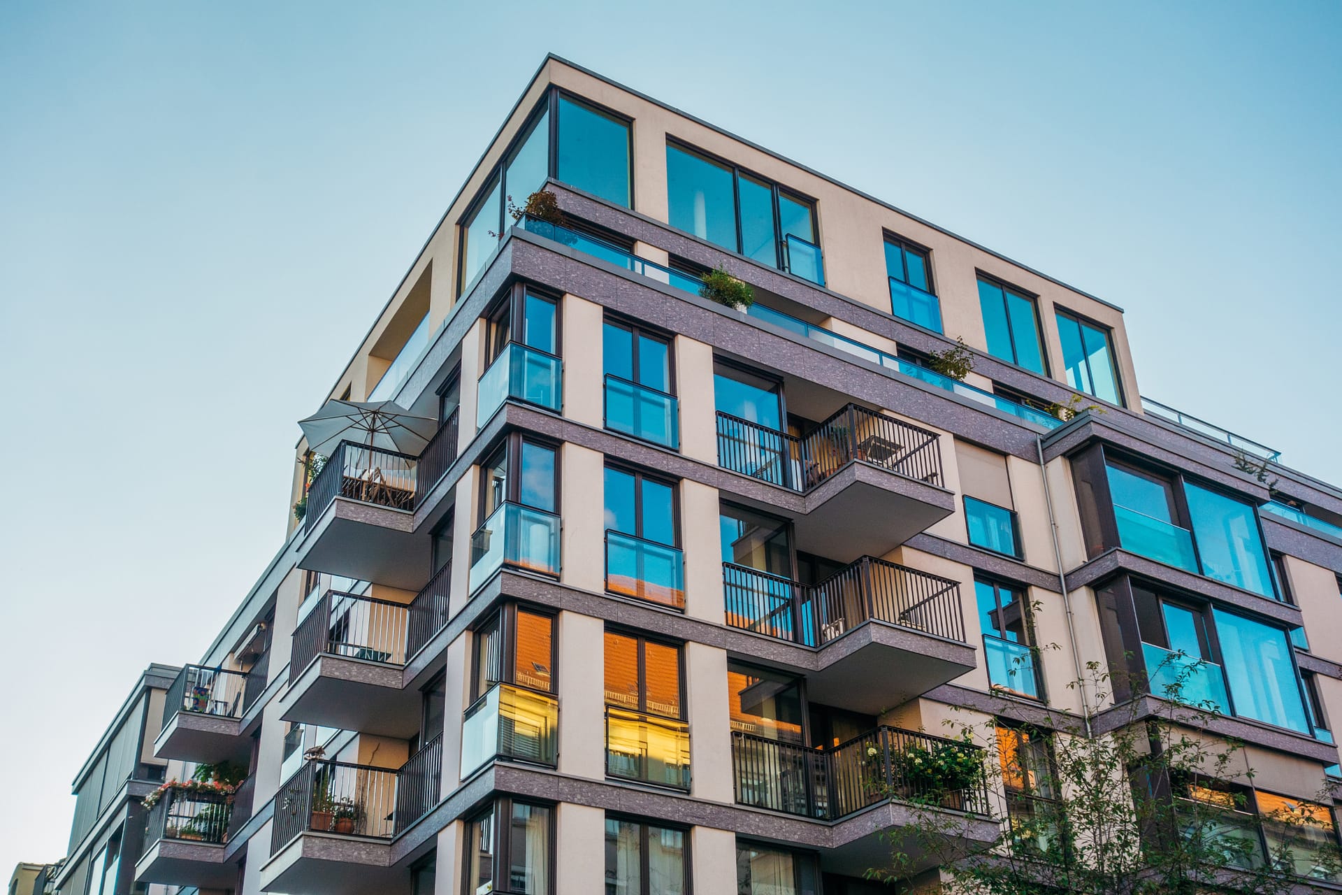 Contemporary multi-story apartment building with glass balconies and modern architectural design