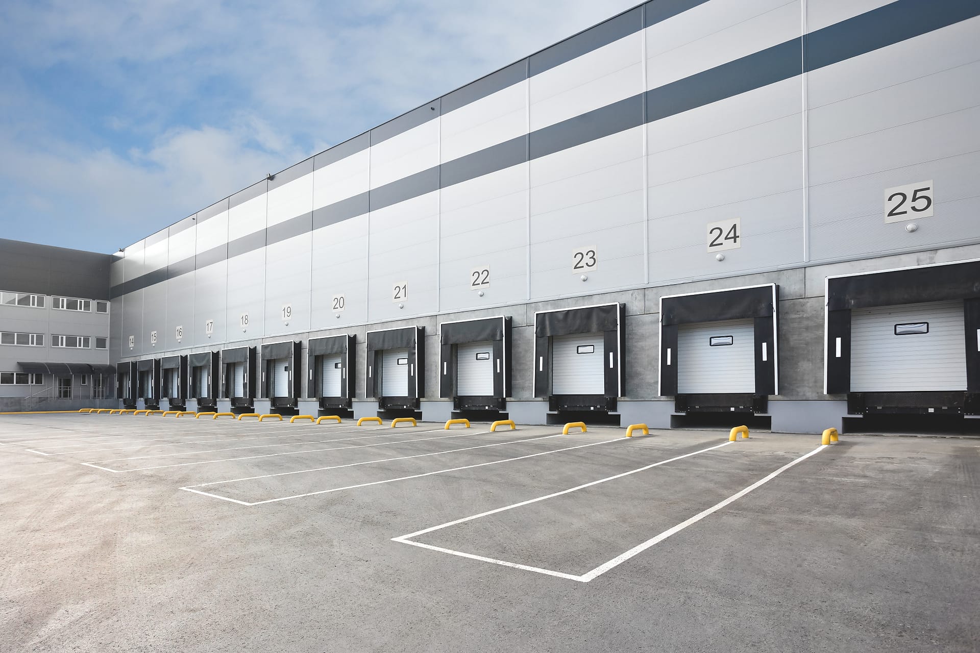 Industrial distribution center exterior with numbered loading dock bays and truck staging areas